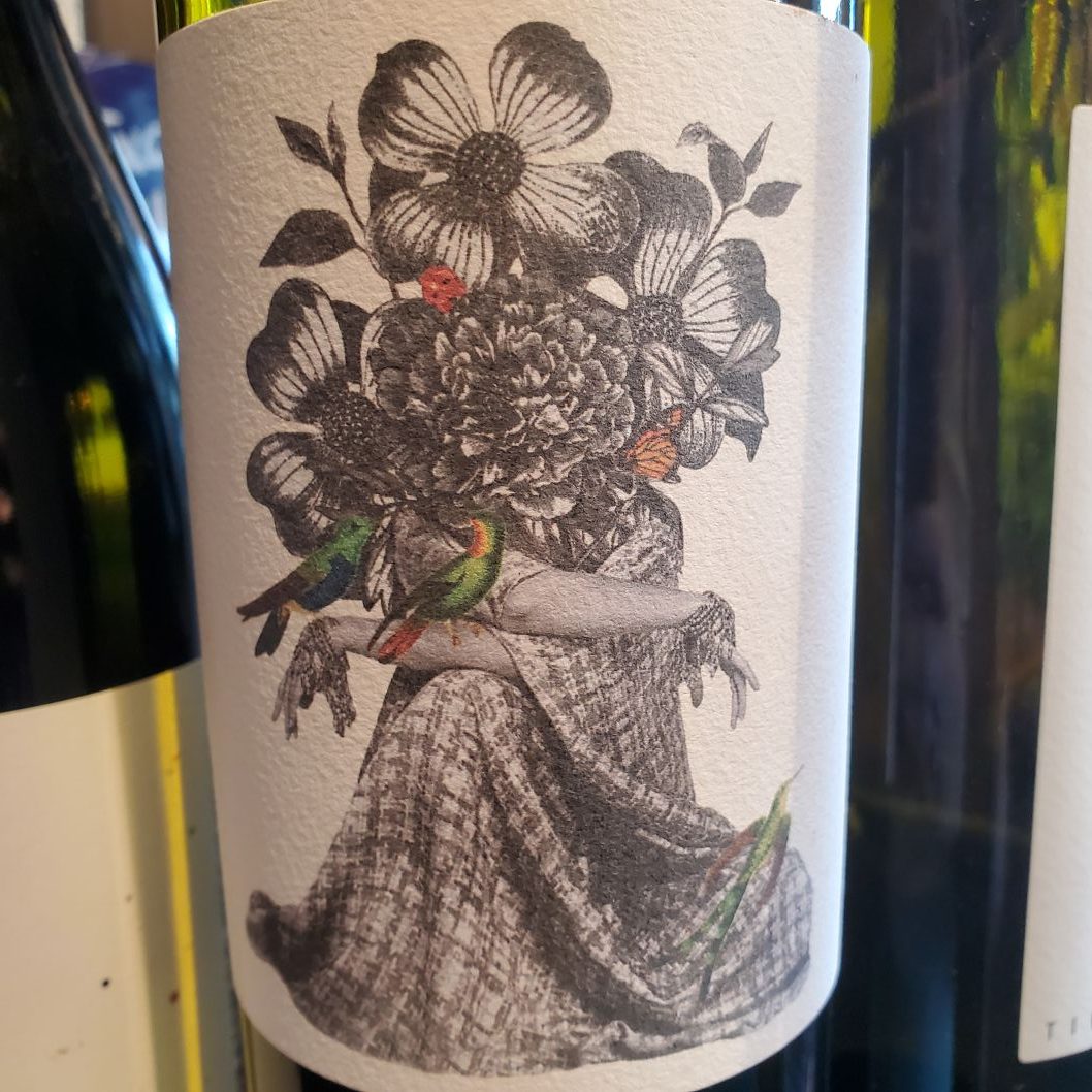 Gallery 2 - wine label with a person in a dress and flowers where a head would be with two green birds on wrist
